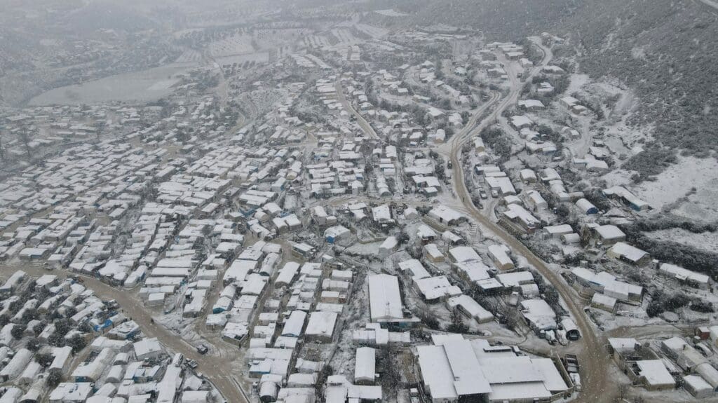 An aerial picture shows a snow-covered camp for internally displaced Syrians in the Khirbet al-Joz area, near the border with Türkiye, 5 February 2023