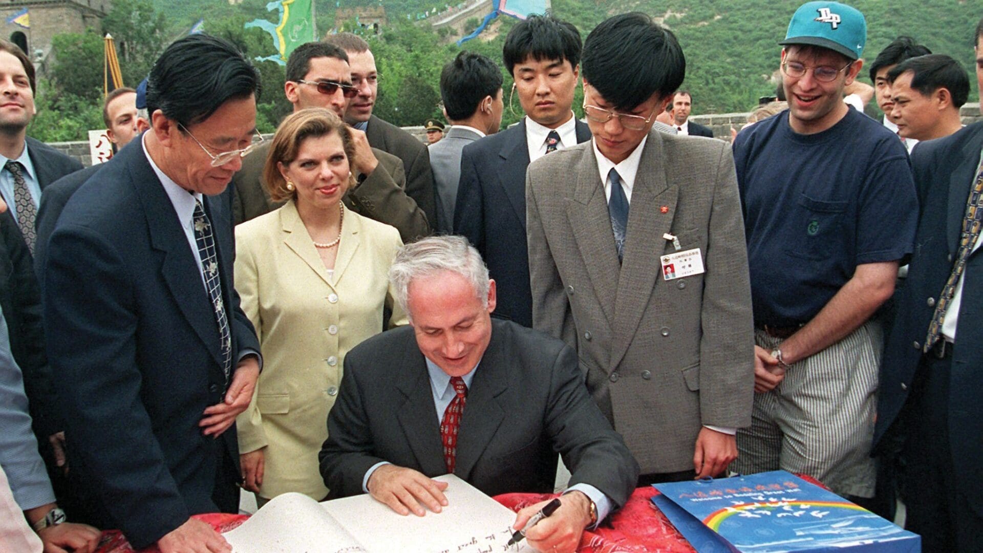 Israeli Prime Minister Benjamin Netanyahu (C) with his wife Sarah behind him, signs the visitor's book on the Great Wall of China at the Badaling Pass just north of Beijing, 27 May 1998