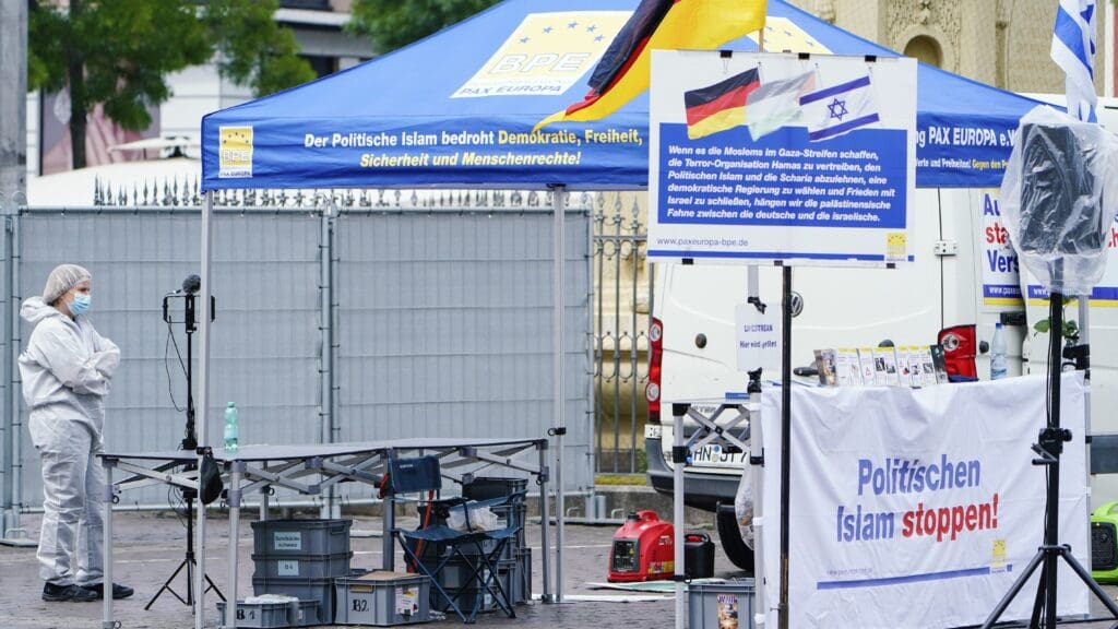 A crime scene investigator standing near the campaign tent of the Pax Europa civic movement on 31 May 2024 following the knife attack in Mannheim, Germany by a man born in Afghanistan but living in Germany.