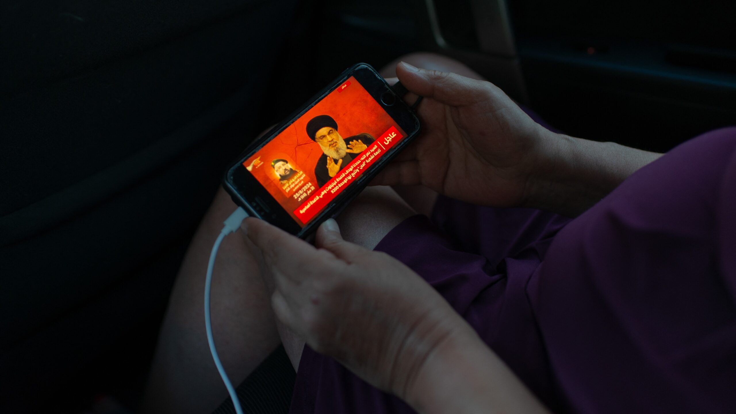 A woman is watching Lebanese Hezbollah Secretary General Hassan Nasrallah’s speech in a car in Batroun, Lebanon on 25 August 2024 after Hezbollah launched 340 rockets on Israel in the morning.