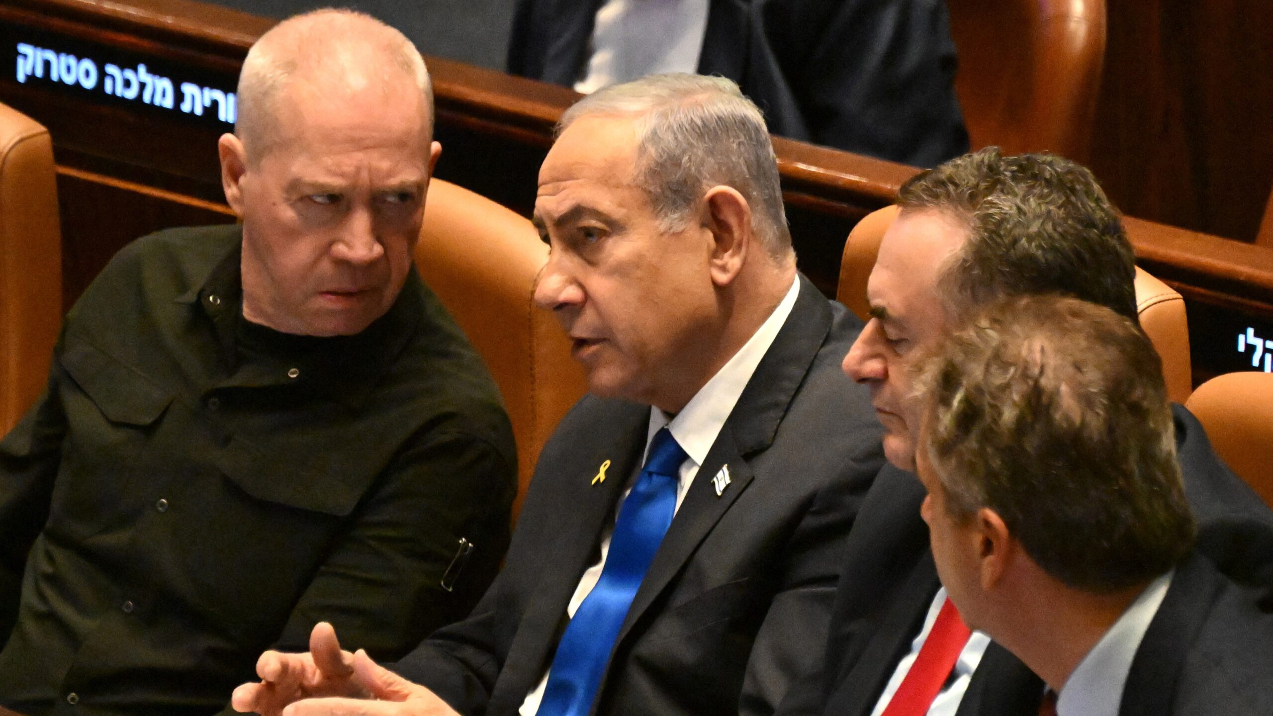 Israeli Prime Minister Benjamin Netanyahu (C) speaks to Defence Minister Yoav Gallant (L) at the opening of the 25th Parliament session in Jerusalem on October 28, 2024.