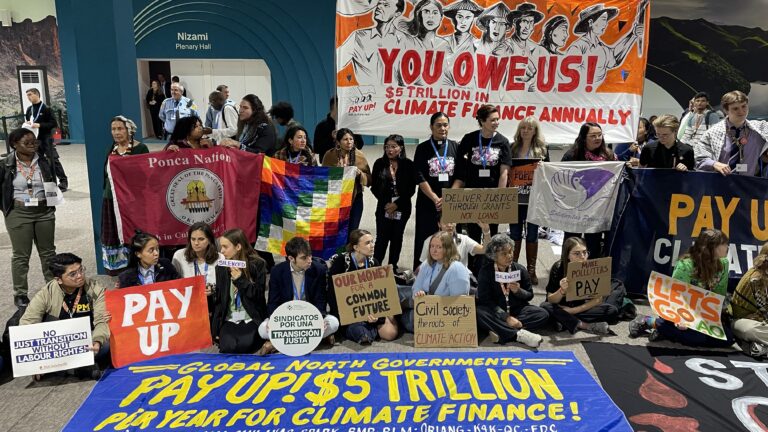 Activists hold a silent protest inside the COP29 venue to demand that rich nations provide climate finance to developing countries, during the United Nations Climate Change Conference (COP29) in Baku on November 16, 2024. (Photo by Laurent THOMET / AFP)