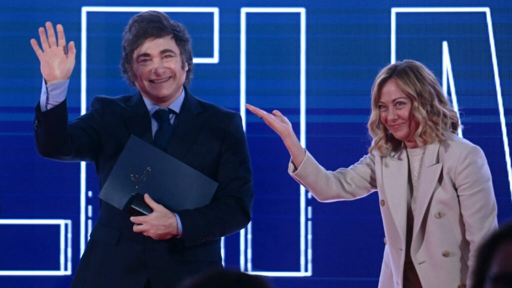 Argentina's President Javier Milei waves from the stage next to Italy's Prime Minister Giorgia Meloni during the Atreju political meeting organised by the young militants of Italian right wing party Brothers of Italy (Fratelli d'Italia) on 14 December 2024 in Rome.