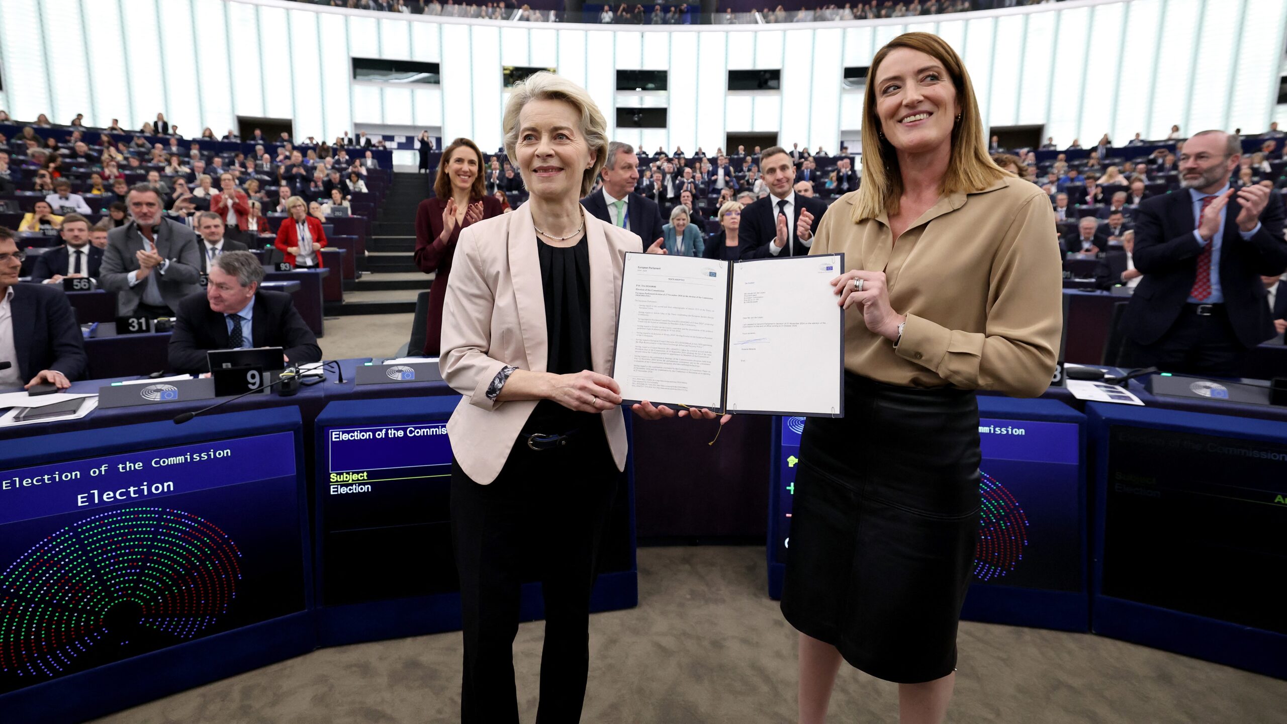 European Commission President-elect Ursula von der Leyen (L) and European Parliament President Roberta Metsola pose with the results of the election of the Commissioners at the European Parliament in Strasbourg on 27 November 2024.